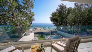 A balcony with a clear view of a beach and pool area.