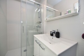Regadera, secadora de cabello, toallas, papel de baño 