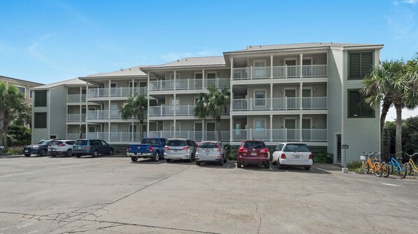 A multi-story building with a parking lot in front.