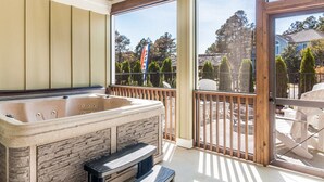 Un espacio de spa con jacuzzi, pared de piedra y terraza de madera.