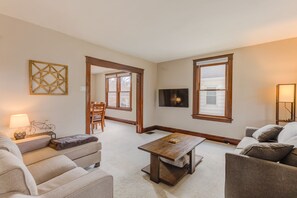 Ein Wohnzimmer mit Sofa, Couchtisch, Fernseher und Kamin.