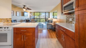 A modern kitchen with wooden cabinets, a built-in oven, and a large island. - Exceptional Maui Vista Condo With Ocean Views (Kihei)
