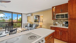 A modern kitchen with a gas stove, microwave, and wooden cabinets. - Exceptional Maui Vista Condo With Ocean Views (Kihei)
