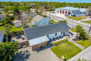 Une maison à deux étages avec un patio couvert, un garage et une petite terrasse.