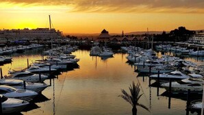 Ein Yachthafen mit zahlreichen Booten, die bei Sonnenuntergang an der Pier festgemacht sind.