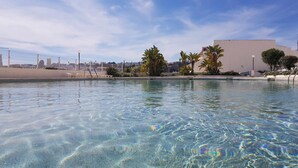 Une piscine aux eaux cristallines, avec une vue sur la ville en arrière-plan.