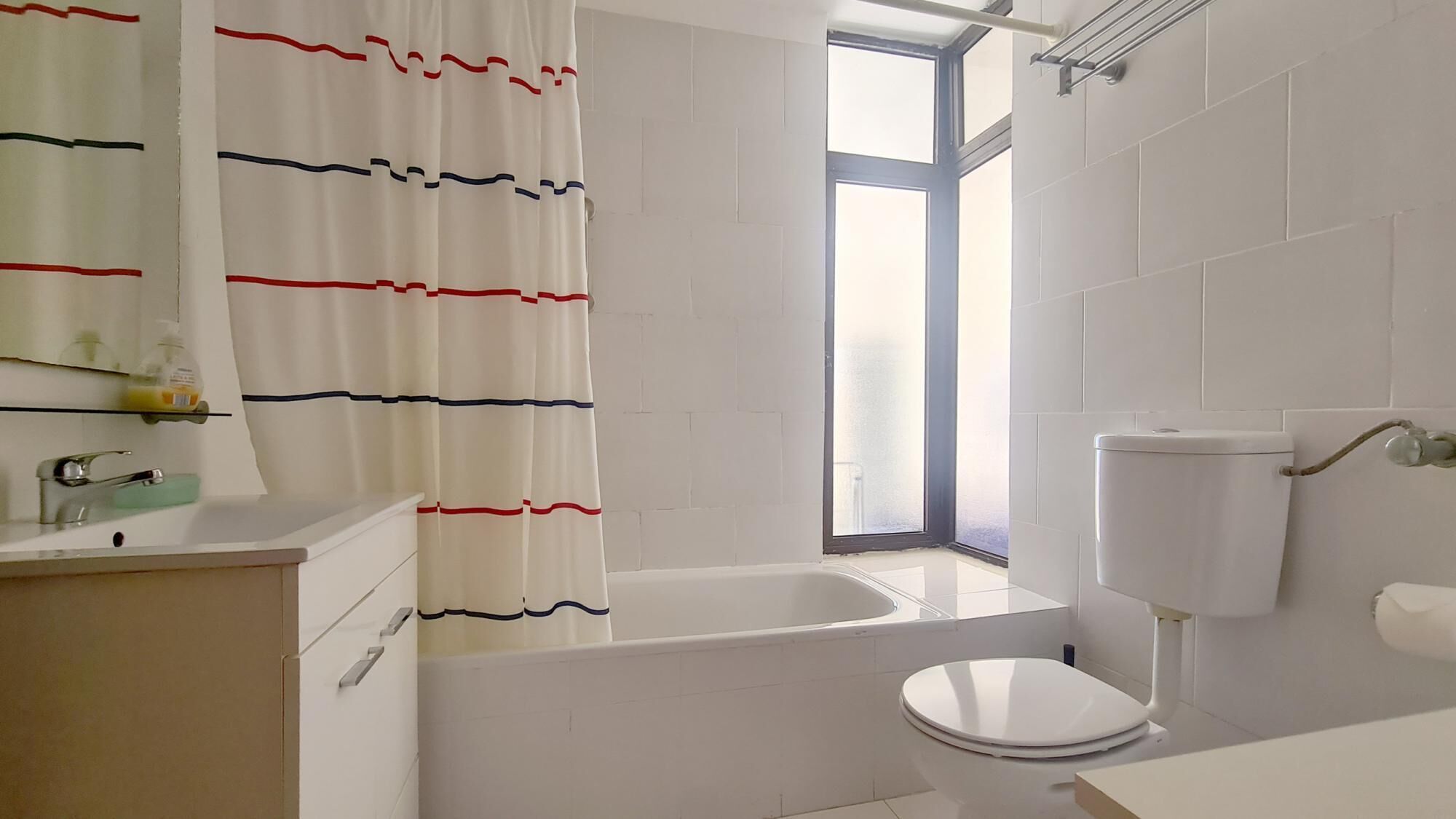 A modern bathroom with a bathtub, toilet, and sink.