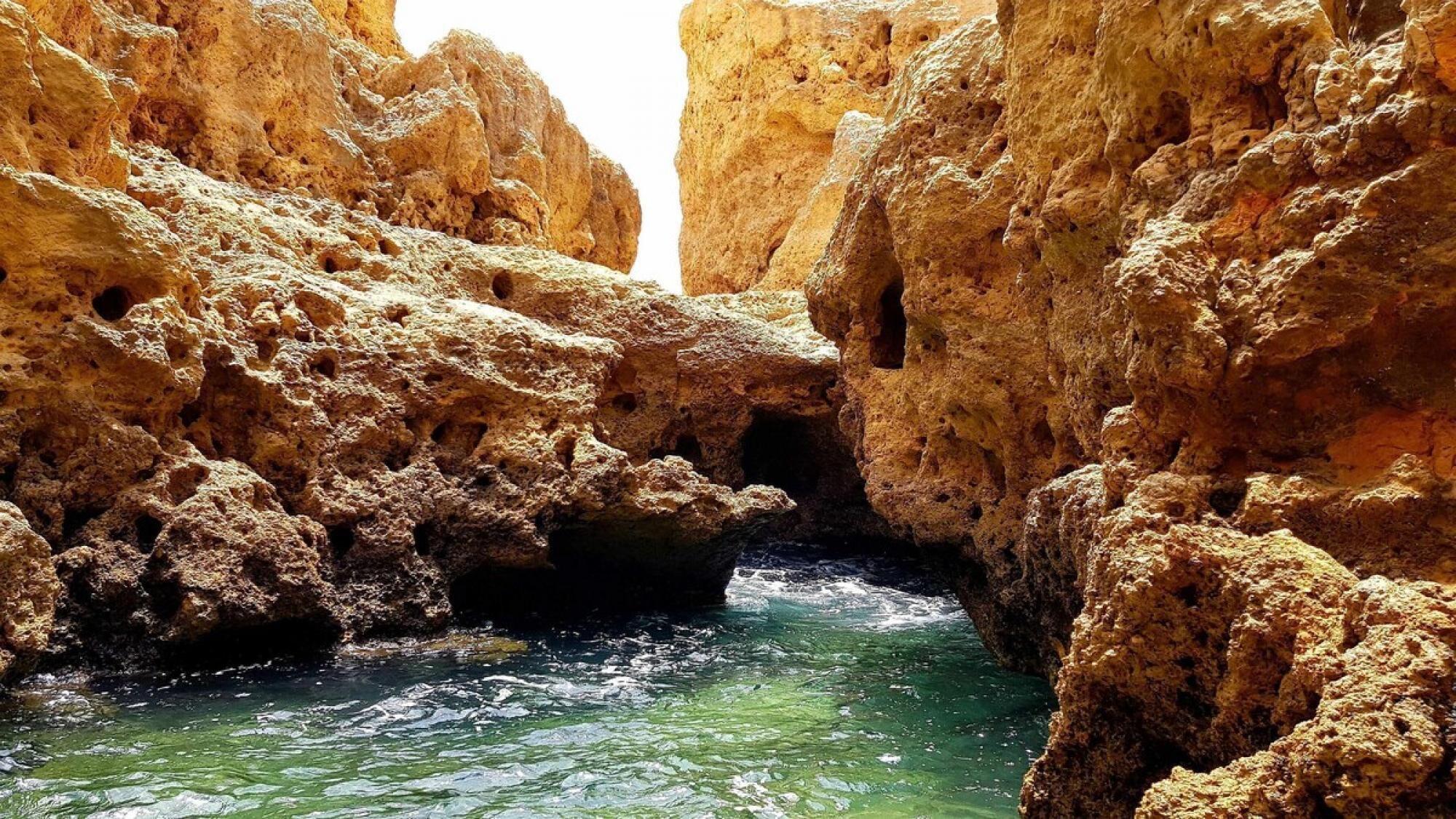 A narrow canyon with rocky walls and a flowing river.