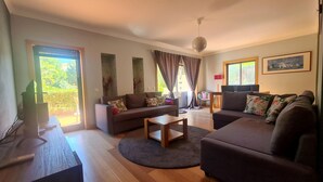 A spacious living room with a sofa set, a coffee table, and a TV.