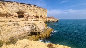 A coastal cliff with multiple caves and a walkway. - Albufeira Balaia Mar e Sol by Rentals in Algarve (Albufeira)