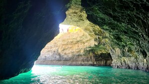 A natural cave formation with clear turquoise water at the base. - Albufeira Balaia Mar e Sol by Rentals in Algarve (Albufeira)