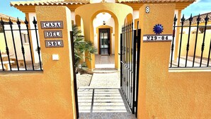 Uma entrada com portão e uma placa com a inscrição 'CASA DEL SOL' e o número 'N29-04'.