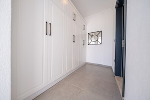 Ein Flur mit weißen Schränken und einem gerahmten Kunstwerk an der Wand.
