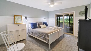 Ein Schlafzimmer mit Bett, Schreibtisch, Stuhl, Kleiderschrank und Deckenventilator.