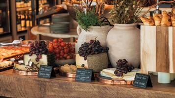 Exhibición de quesos y vinos, con diferentes tipos de queso y uvas.