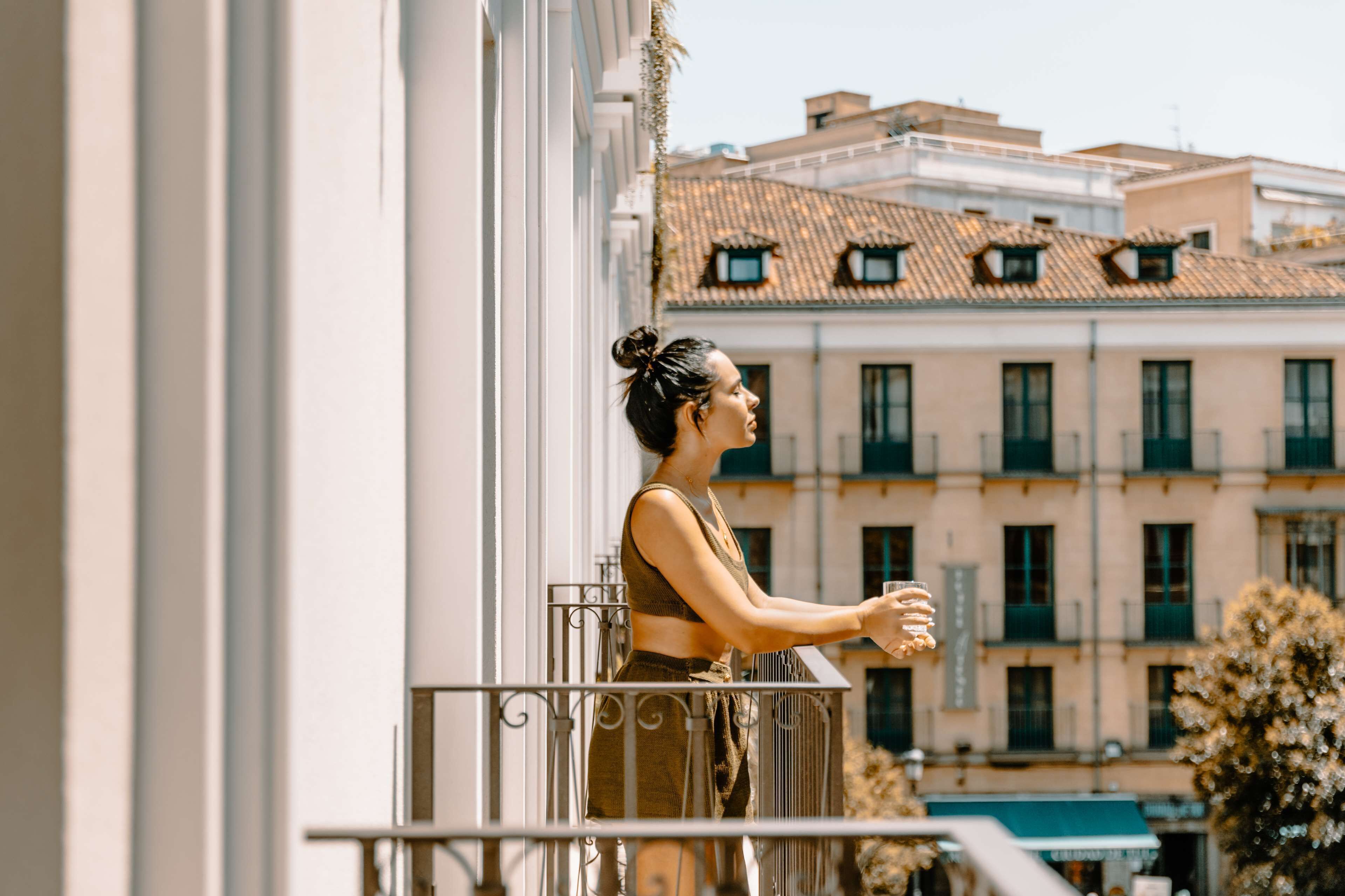 Un balcon avec une balustrade, un immeuble avec de nombreuses fenêtres et des balcons en arrière-plan.