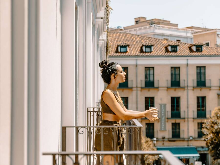 Un balcon avec une balustrade, un immeuble avec de nombreuses fenêtres et des balcons en arrière-plan.