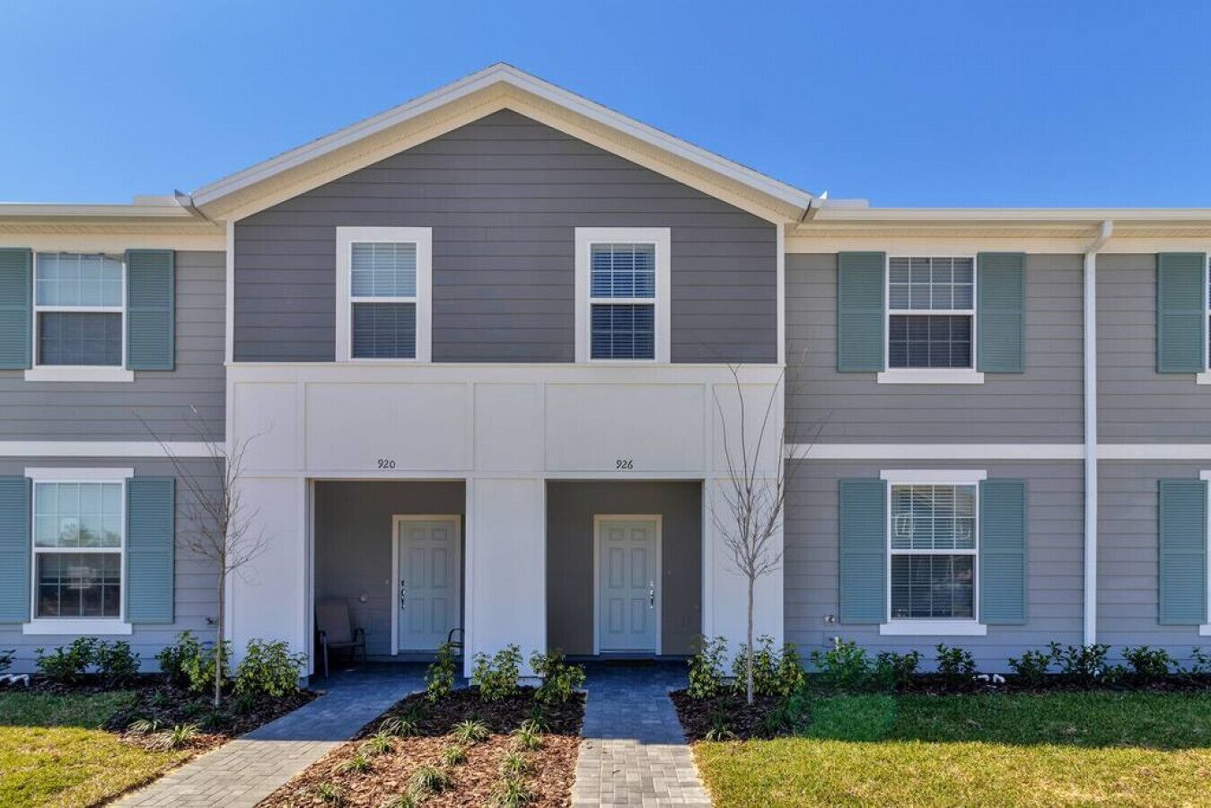 A two-story residential building with a symmetrical facade, numbered units 920 and 926, and a central entrance with a small porch.