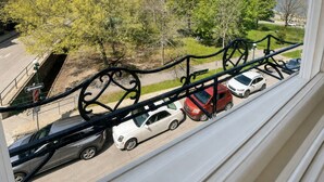 A view from a window overlooking a parking area with cars, trees, and a historic building in the background. - Manoir Sainte Geneviève (Québec City)