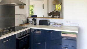 A modern kitchen with a built-in stove, oven, and a large mirror above the counter. - Bleu Comme Toit 3425 (Les Issambres)