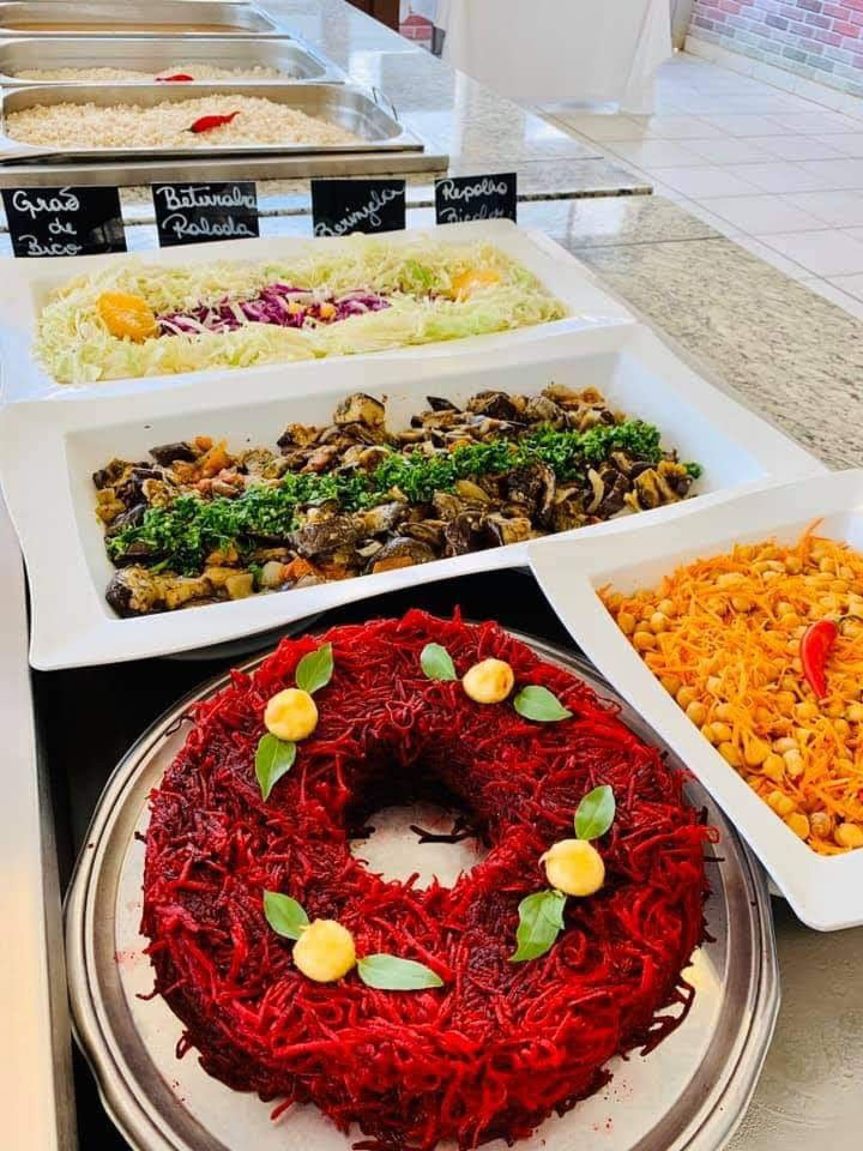 A buffet with various dishes including a large platter of red beet salad garnished with nuts and leaves.