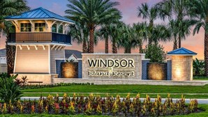 L'ingresso di un resort con un cartello che riporta "Windsor Island Resort", una struttura coperta e palme.