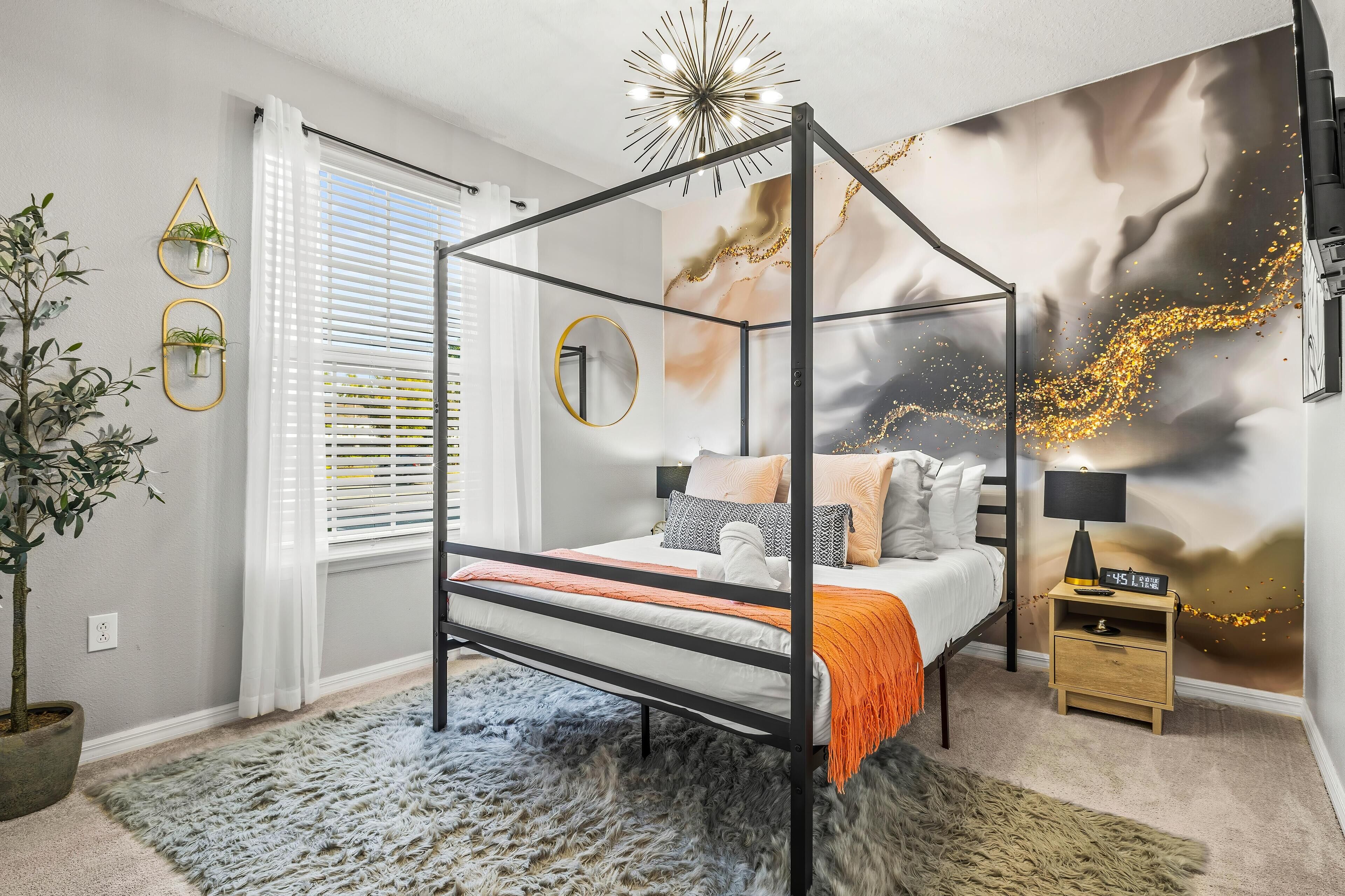 Un lit à baldaquin au design moderne, une table de chevet avec une horloge et une fresque murale.