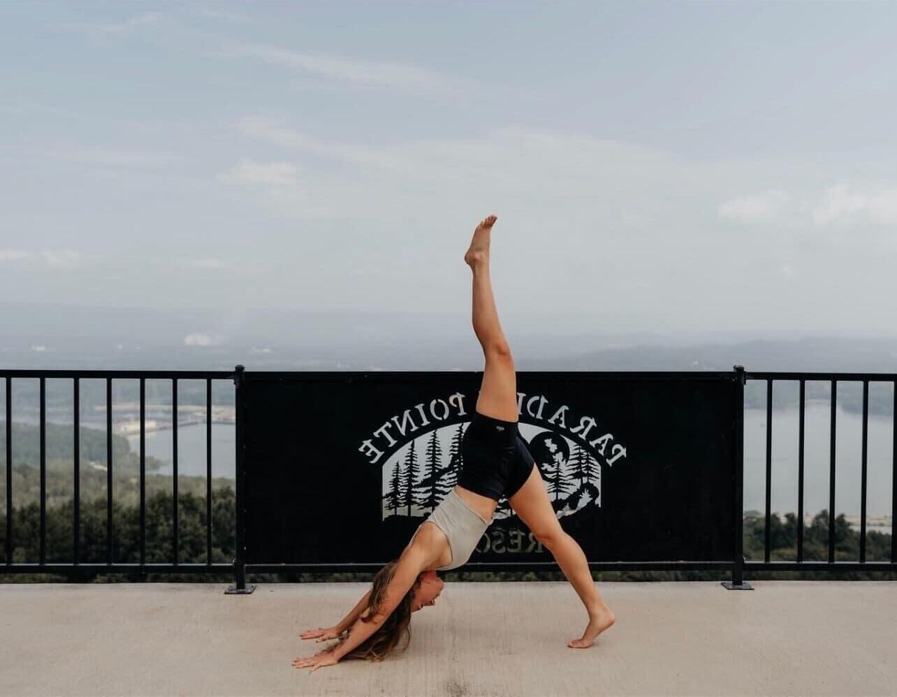 Iemand doet een handstand voor een achtergrond met een bord waarop 'BALDWIN TOWNS' staat.