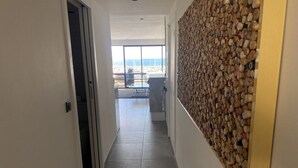 Un couloir menant à un balcon d’où l’on peut admirer la mer.