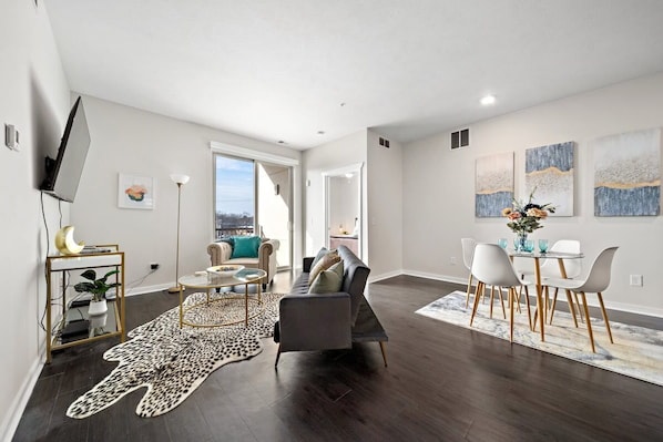 A modern living room with a sofa, coffee table, and dining area.