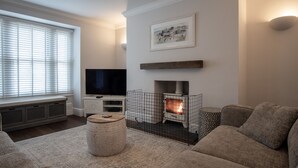 Ein Wohnzimmer mit Kamin, Fernseher und einer Couch.