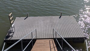 A wooden dock extending into a calm body of water with a distant shoreline. - Small rustic cabin on KY Lake (sleeps 4) (New Concord)