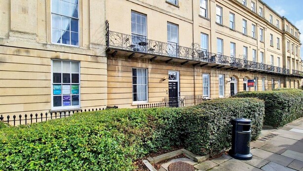 A multi-story building with a row of windows, a black metal fence, and a hedge in front. - Margaret's Loft by Fortuna Property Portfolio, The Margaret's Loft Apartment (Cheltenham)
