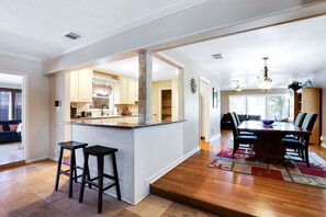 A spacious kitchen with a central island, a dining area with a large table, and a living room with a sofa. - Fortuitous - A Birdy Vacation Rental (San Antonio)