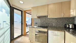 A modern kitchen with granite countertops, stainless steel appliances, and wooden cabinets.