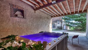 Un espace de bien-être avec un jacuzzi, des bougies et des plantes.
