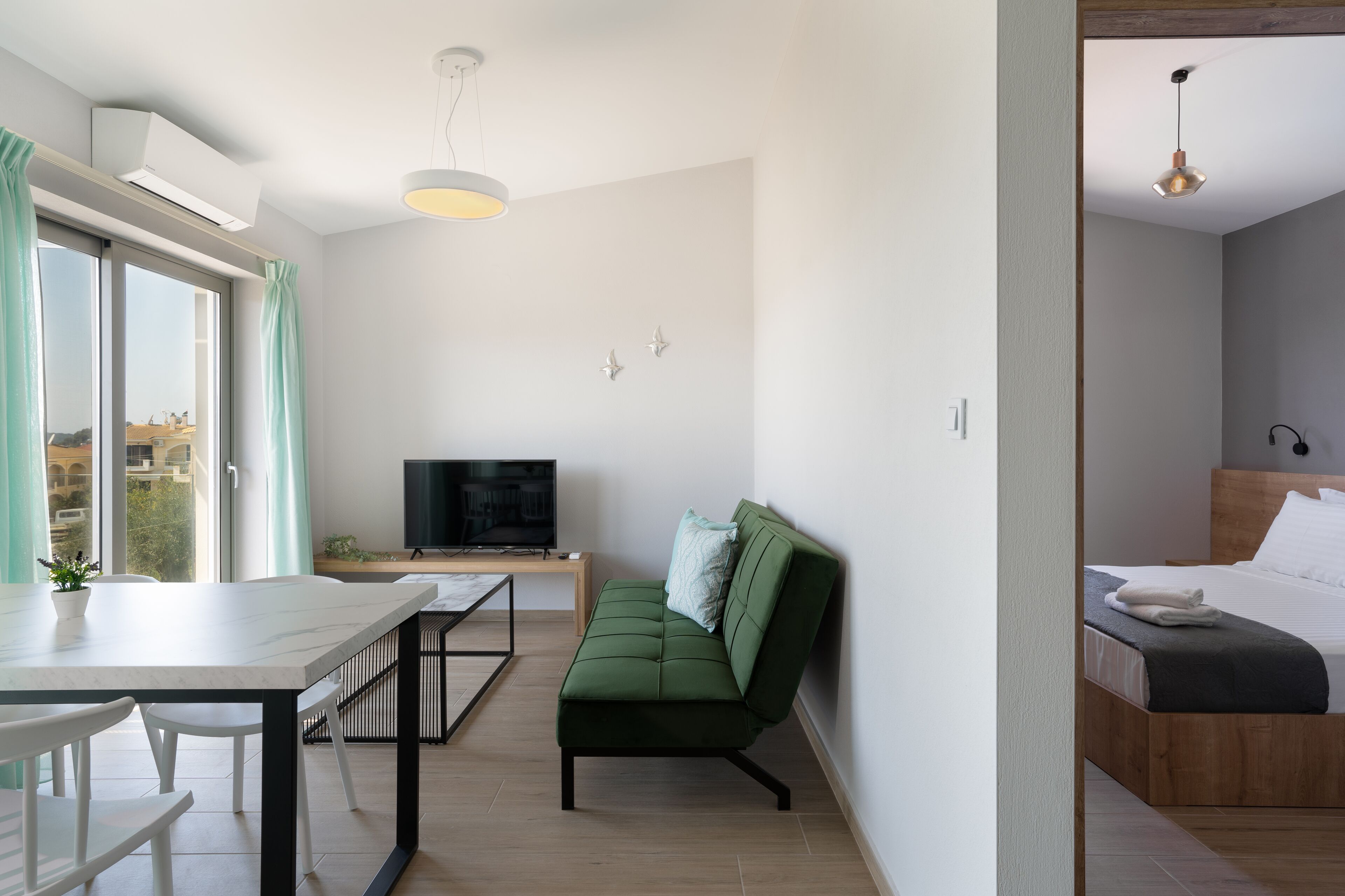 Una sala de estar moderna con un sofá, una mesa de comedor y un televisor.