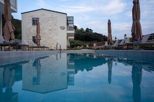 Una piscina al aire libre de temporada, sombrillas