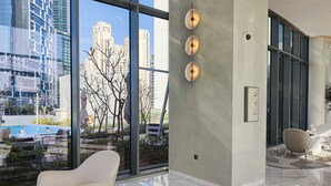 Un hall d’hôtel moderne avec de grandes fenêtres, une vue sur la piscine et un design minimaliste.