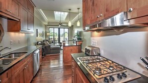 Une cuisine moderne avec des meubles en bois, une cuisinière à gaz et un lave-vaisselle.