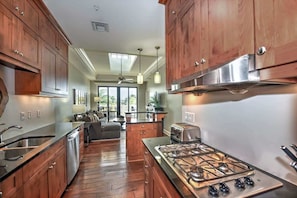 Una cucina moderna con mobili in legno, piano cottura a gas e lavastoviglie.