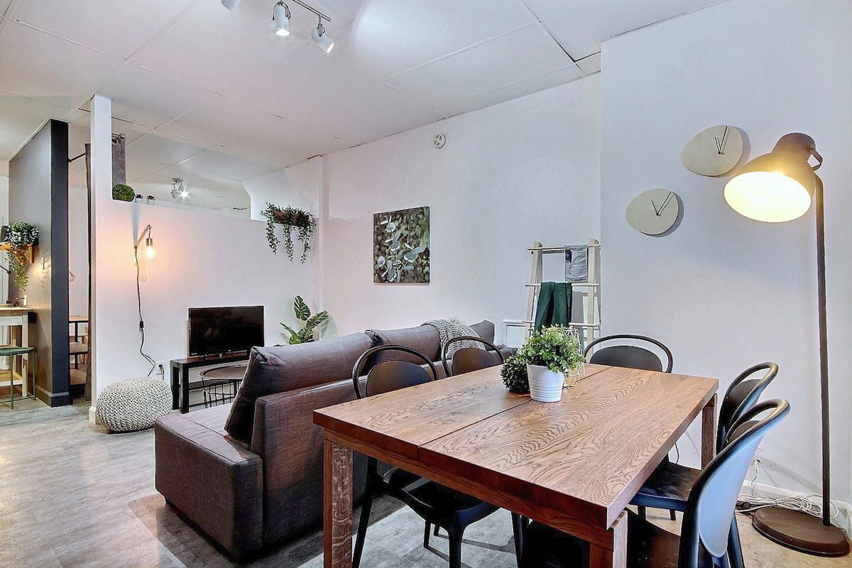 Un espacio moderno para vivir con una mesa de comedor de madera, un sofá y un televisor.