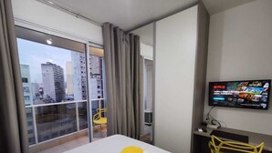 A hotel room with a bed, a TV, a desk, and a chair. - 123 Quarto - Sé (São Paulo)