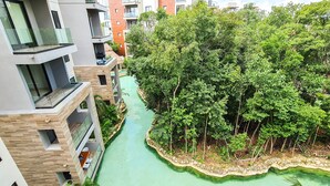 A modern apartment complex with a central water feature surrounded by lush greenery. - Private Garden Condo by Concierge4u (Playa del Carmen)