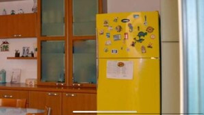 Una cocina con armarios de madera, un refrigerador amarillo y una ventana con vidrio esmerilado.