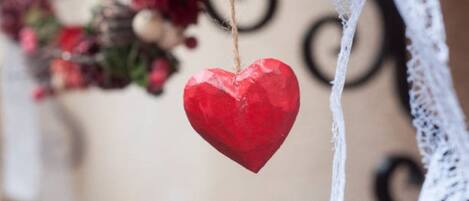 A red heart-shaped ornament hanging from a string.