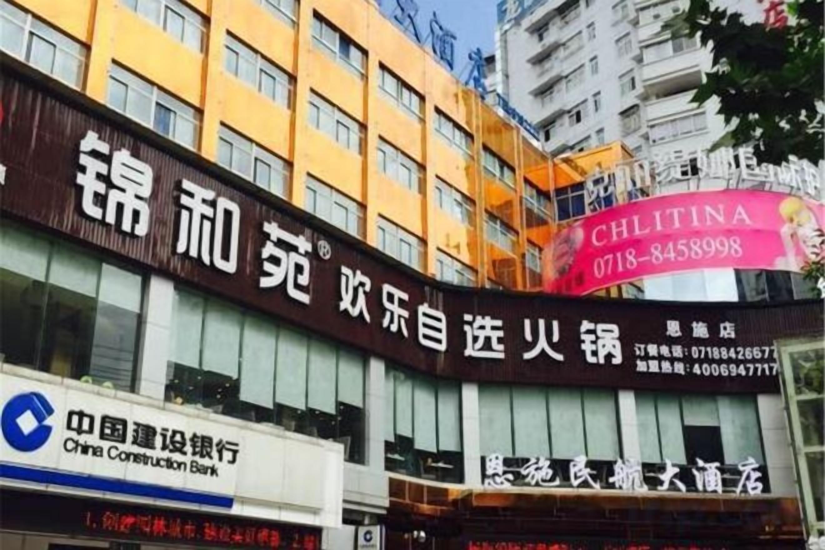 A multi-story building with signage for a restaurant and a bank.