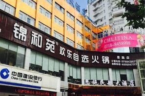 A multi-story building with signage for a restaurant and a bank. - Minhang Hotel (Enshi City)