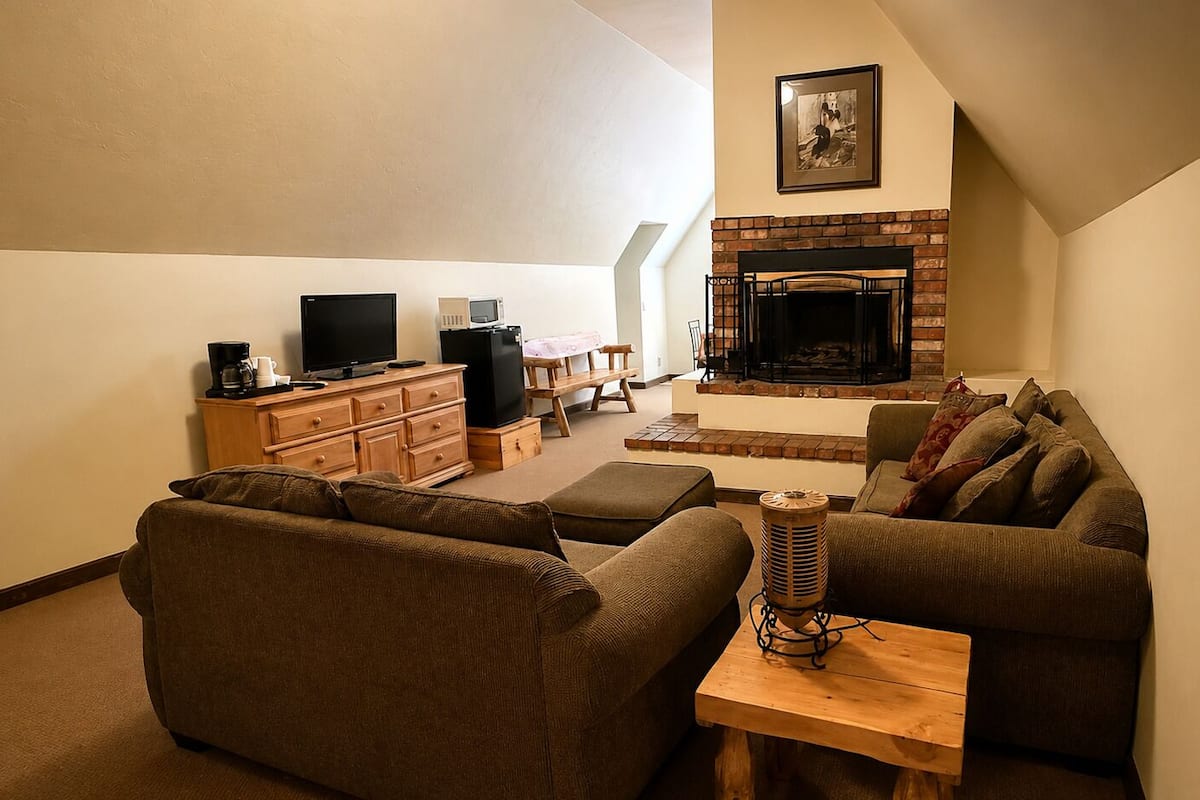 A living room with a fireplace, a television, and a sofa.