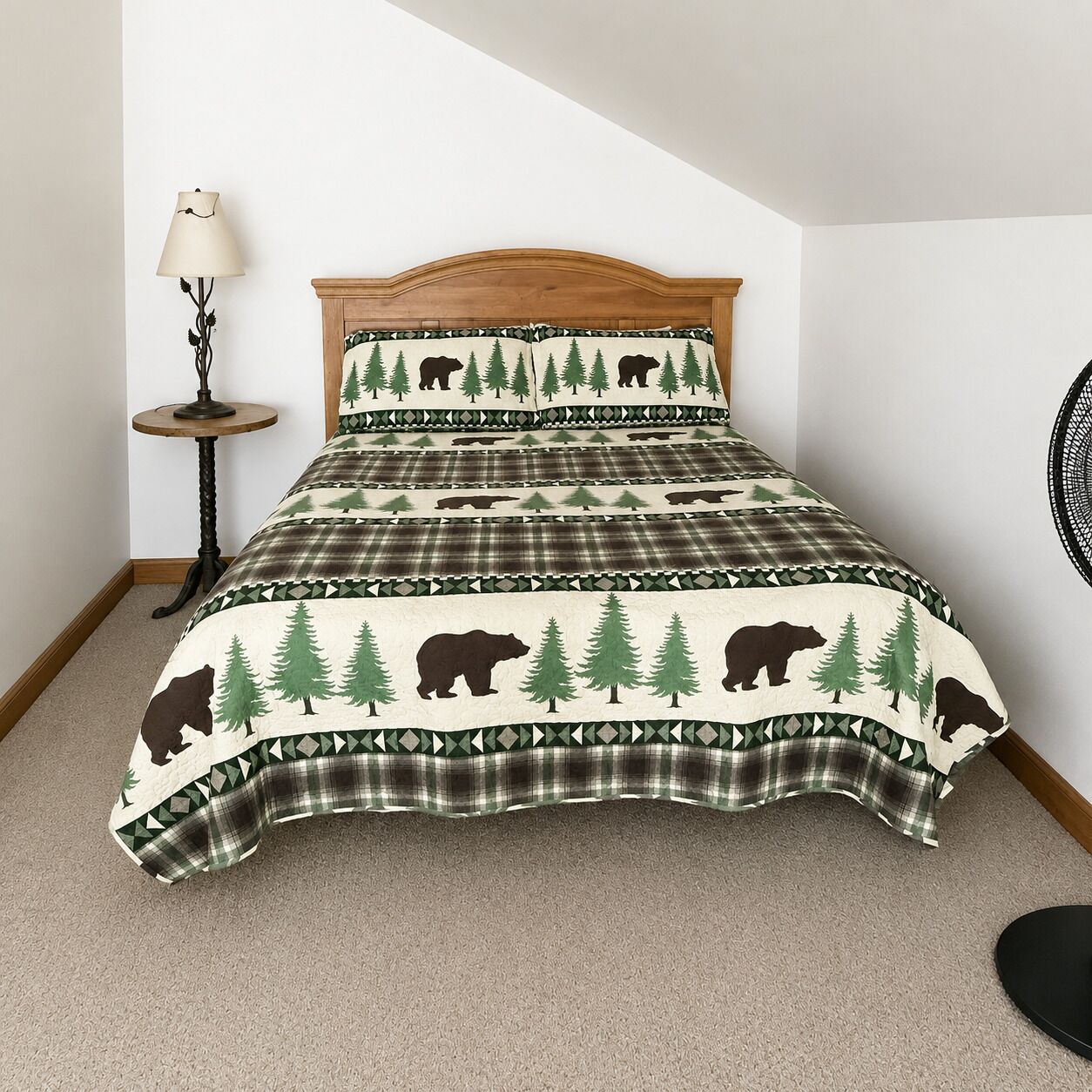 A bedroom with a bed, a lamp, and a wall-mounted fan.